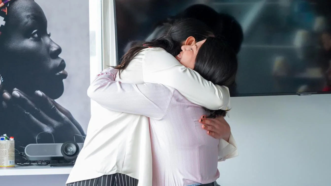 Dos mujeres se abrazan al cierre de un encuentro.