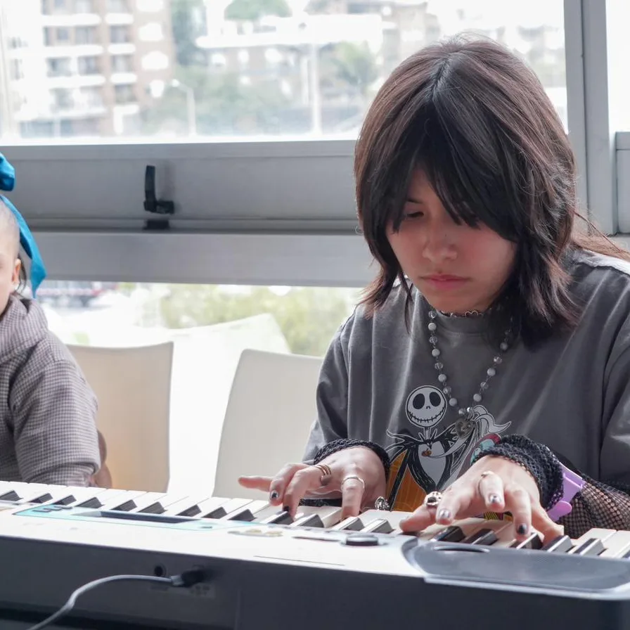 Una joven toca un teclado durante un encuentro de arte y expresión.